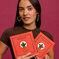Woman holding two red 'Nopalera' packages against a pink background