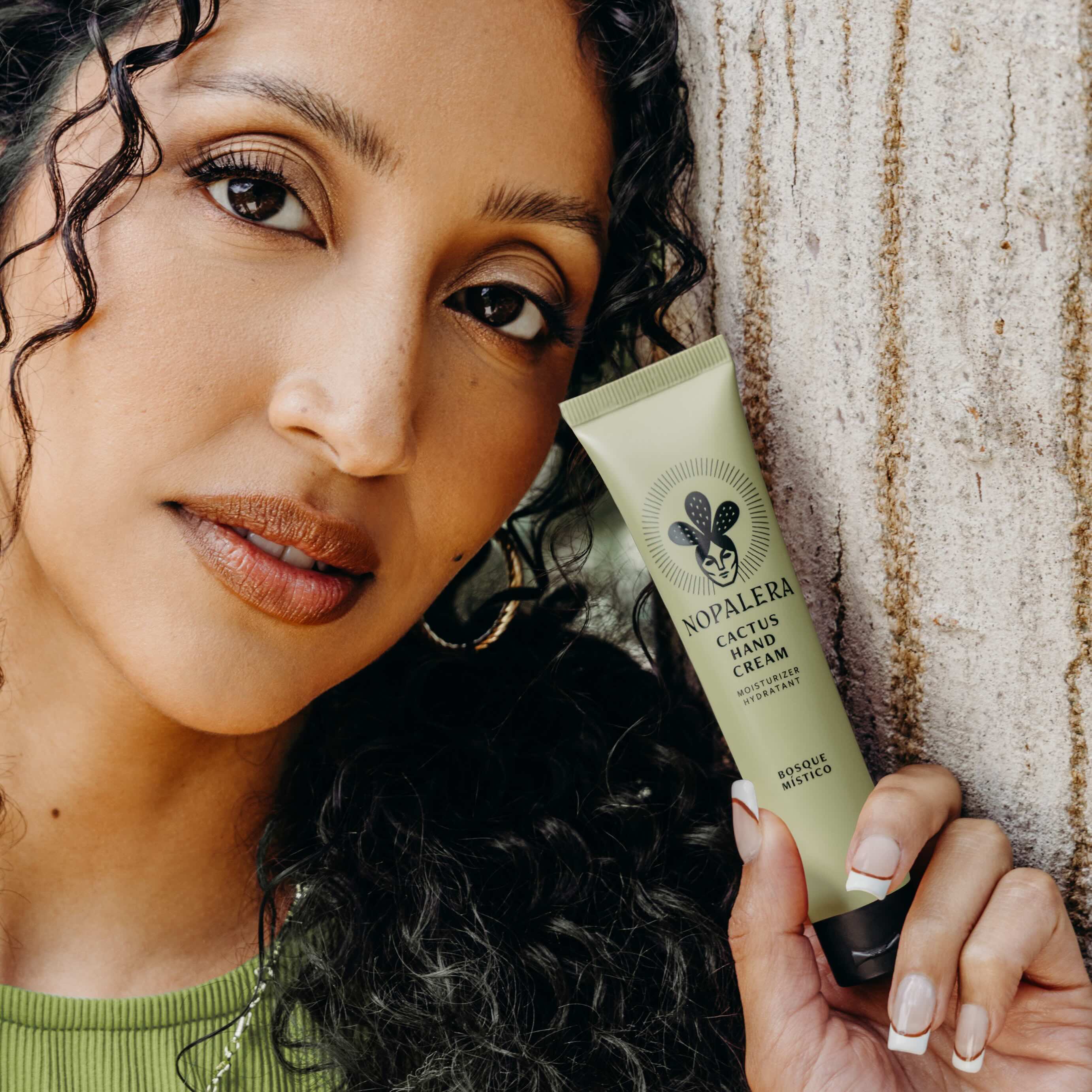 Woman holding a tube of nopalera cactus hand cream bosque místico