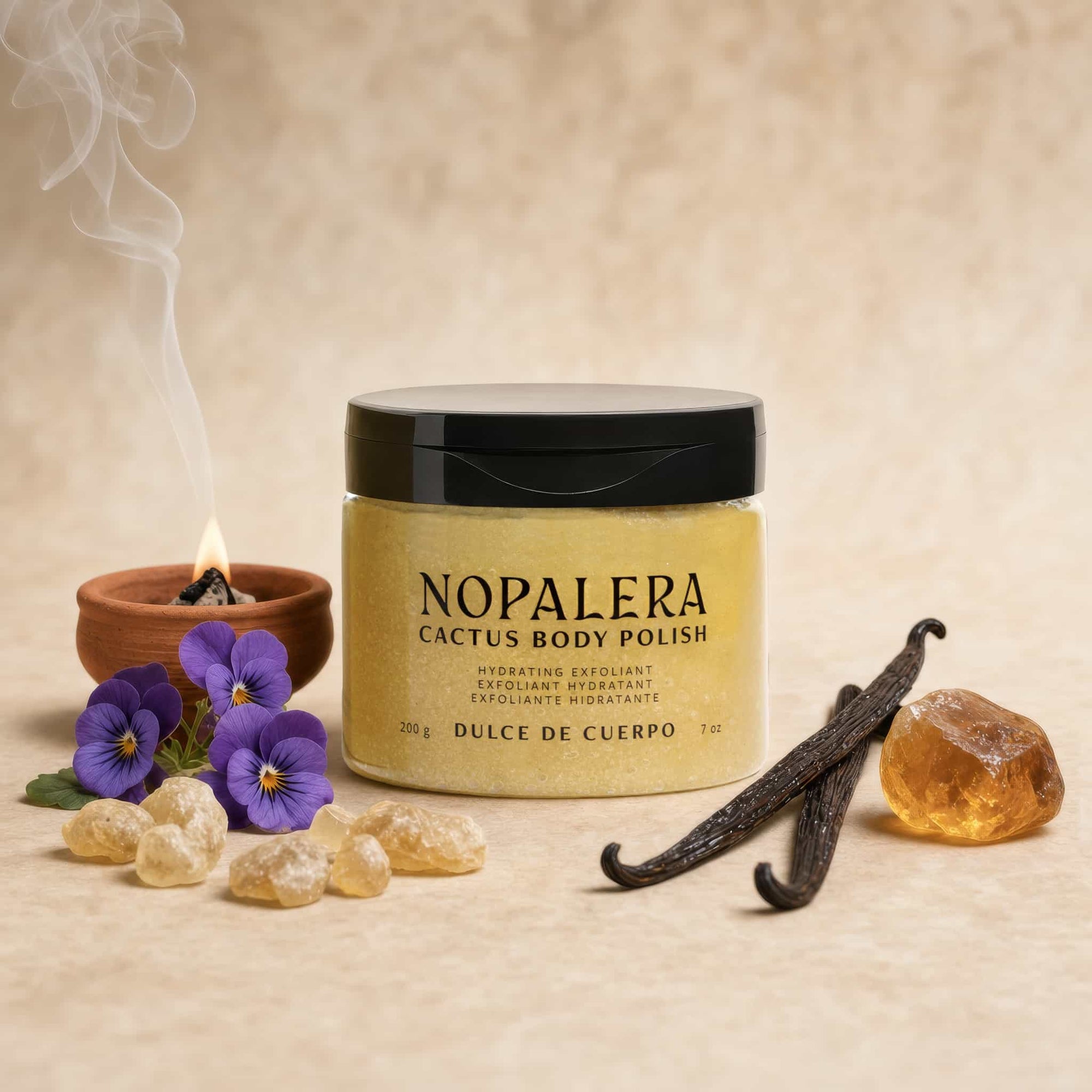 Nopalera cactus body polish Dulce de Cuerpo jar with vanilla beans, flowers, and honey on a beige background