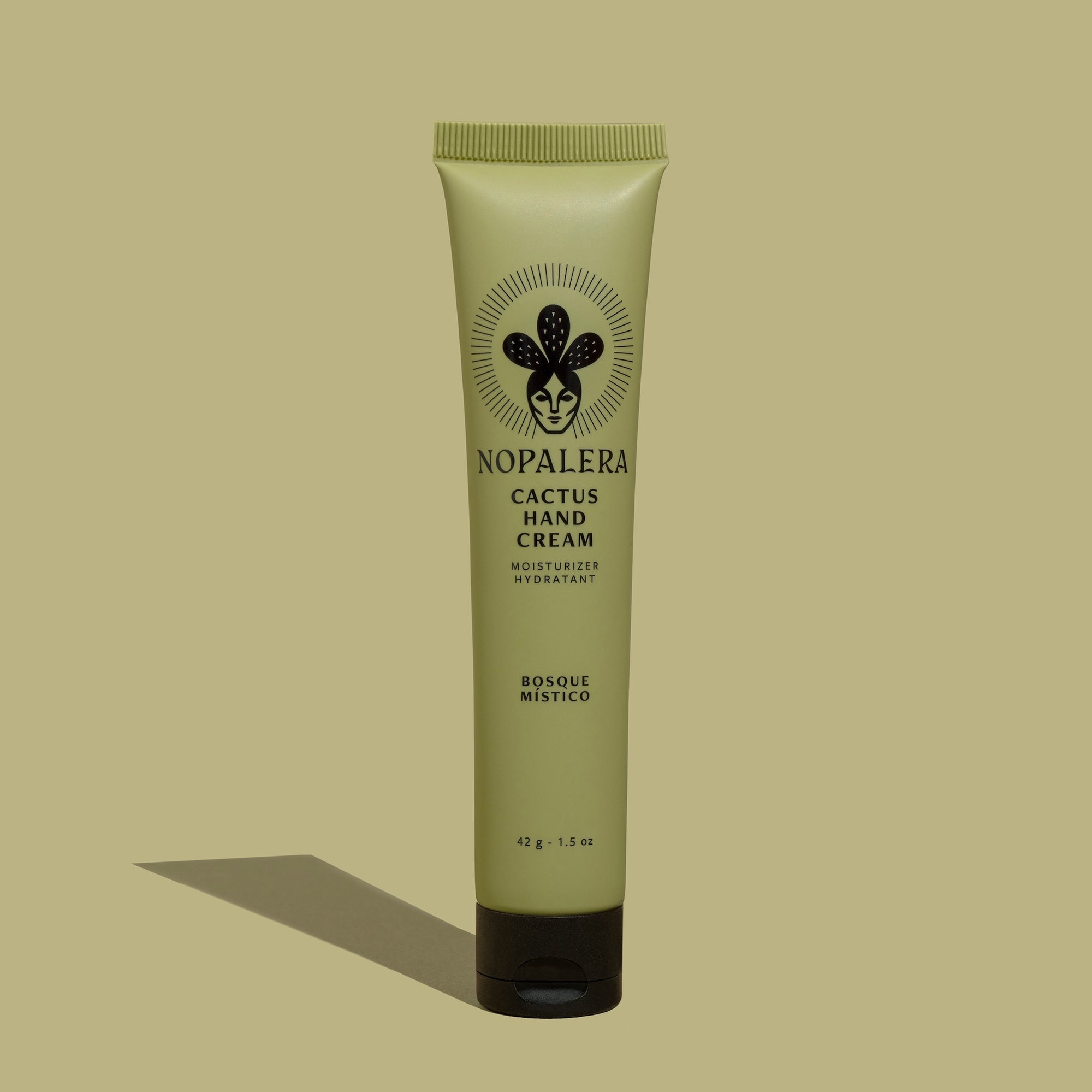 Tube of Nopalera Bosque Místico Cactus Hand Cream with a green  bottle and label featuring the brand name and an illustration of a cactus. The background is green.