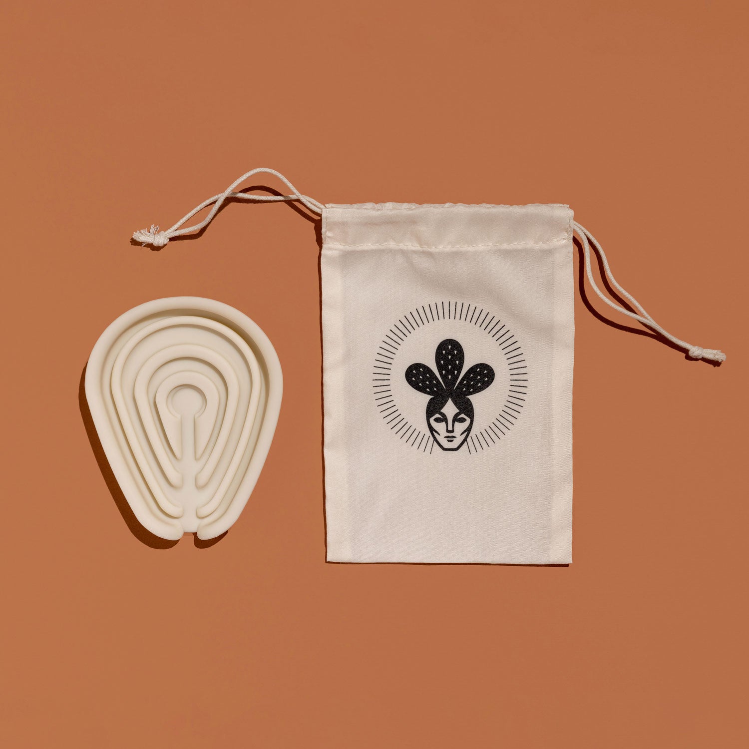 Silicone soap tray beside a Nopalera drawstring storage pouch on a warm tan background.