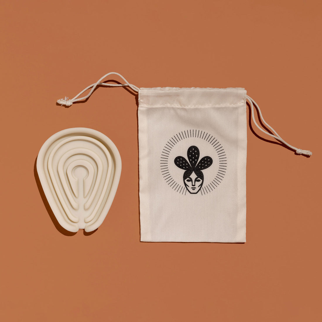 Silicone soap tray beside a Nopalera drawstring storage pouch on a warm tan background.