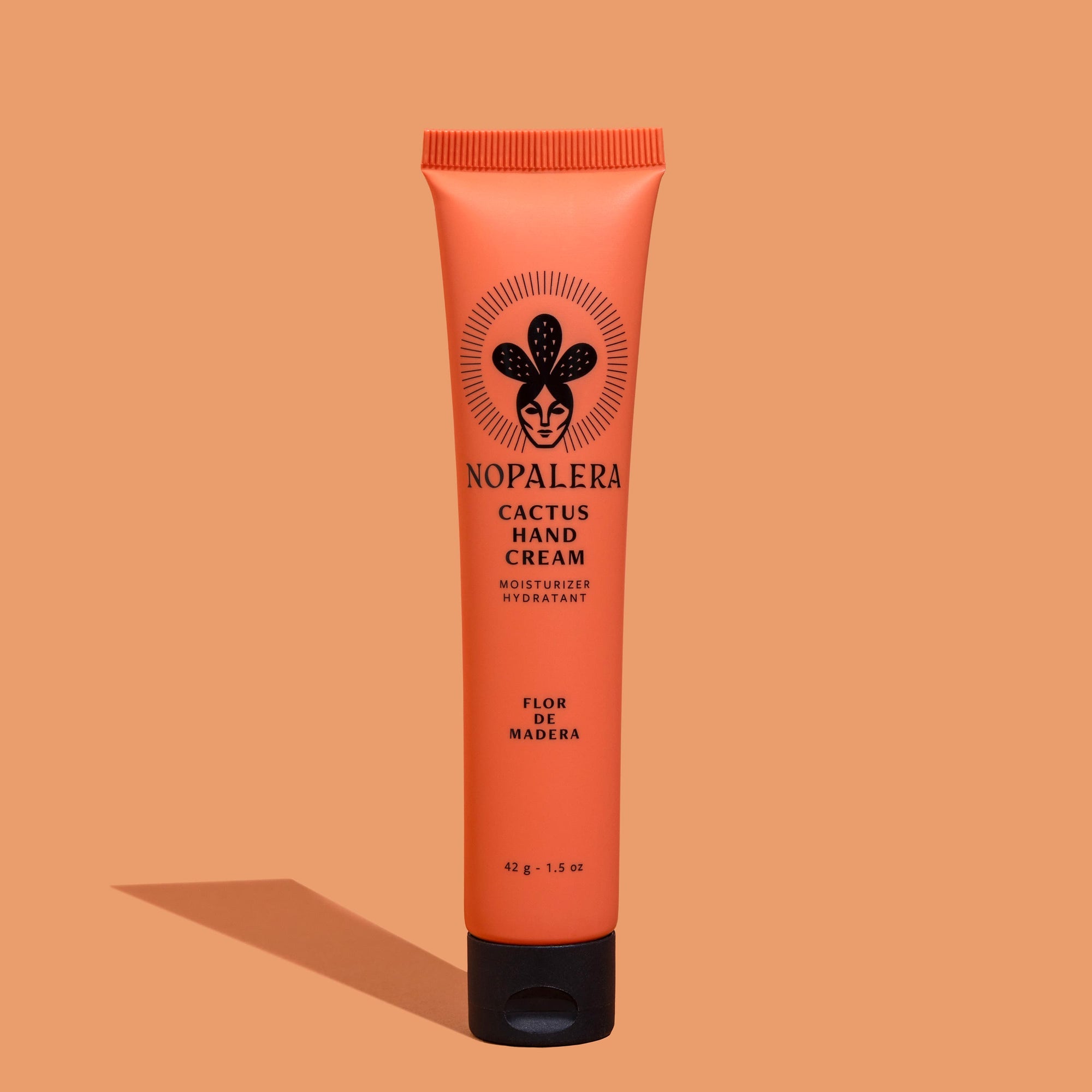 Tube of Nopalera Cactus Hand Cream  Flor de Madera with a peach-colored background, featuring the product name and an illustration of a cactus.