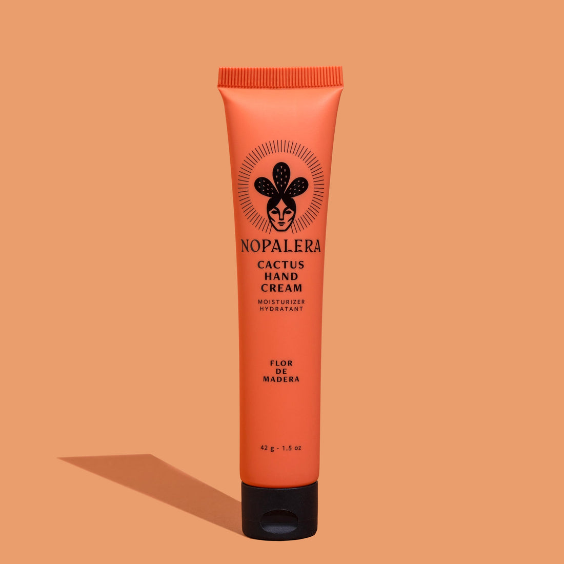 Tube of Nopalera Cactus Hand Cream  Flor de Madera with a peach-colored background, featuring the product name and an illustration of a cactus.
