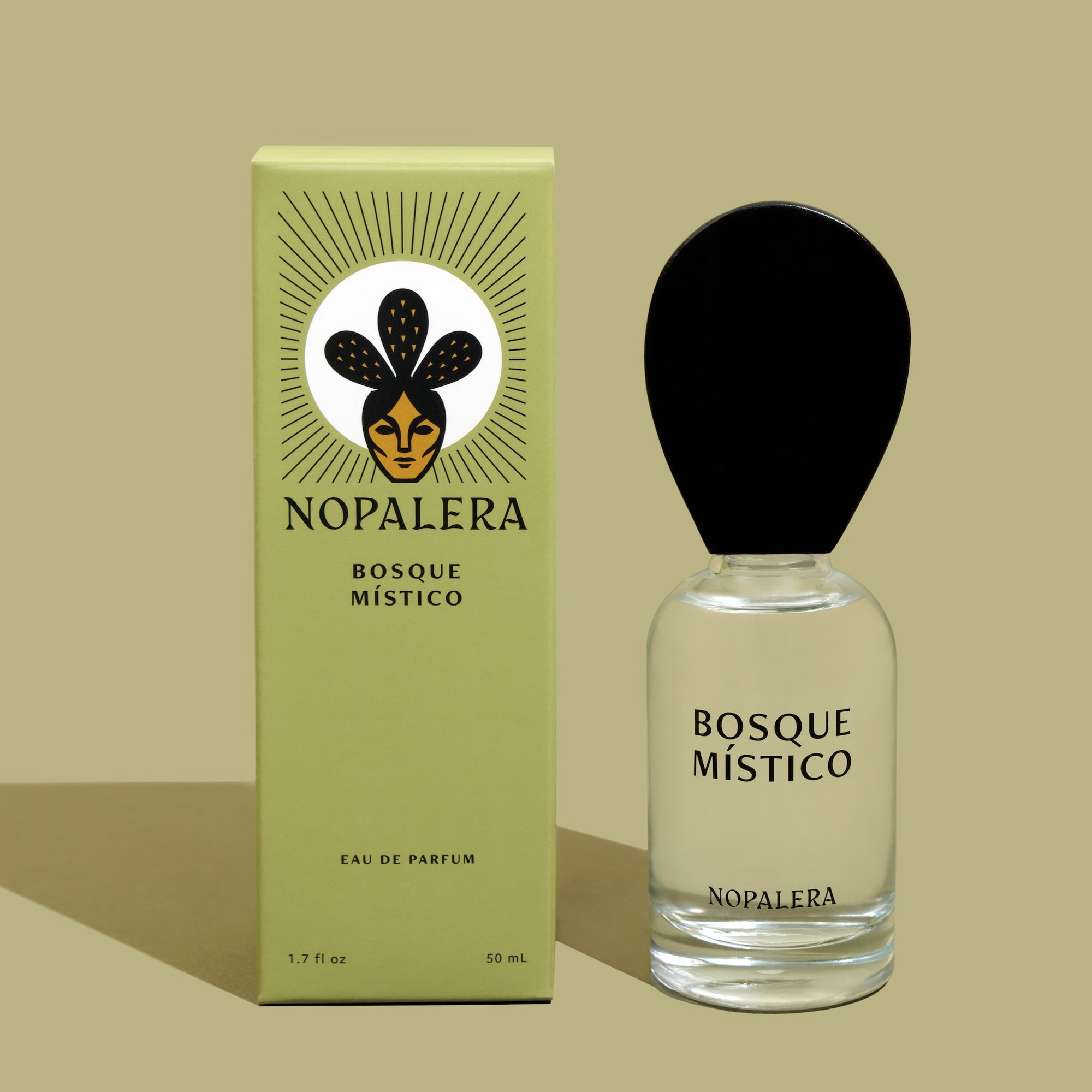 A glass bottle of Luxury Mexican fragrance Bosque Místico perfume with a black cap, next to its green packaging box with a floral illustration and the brand name 'Nopalera'.