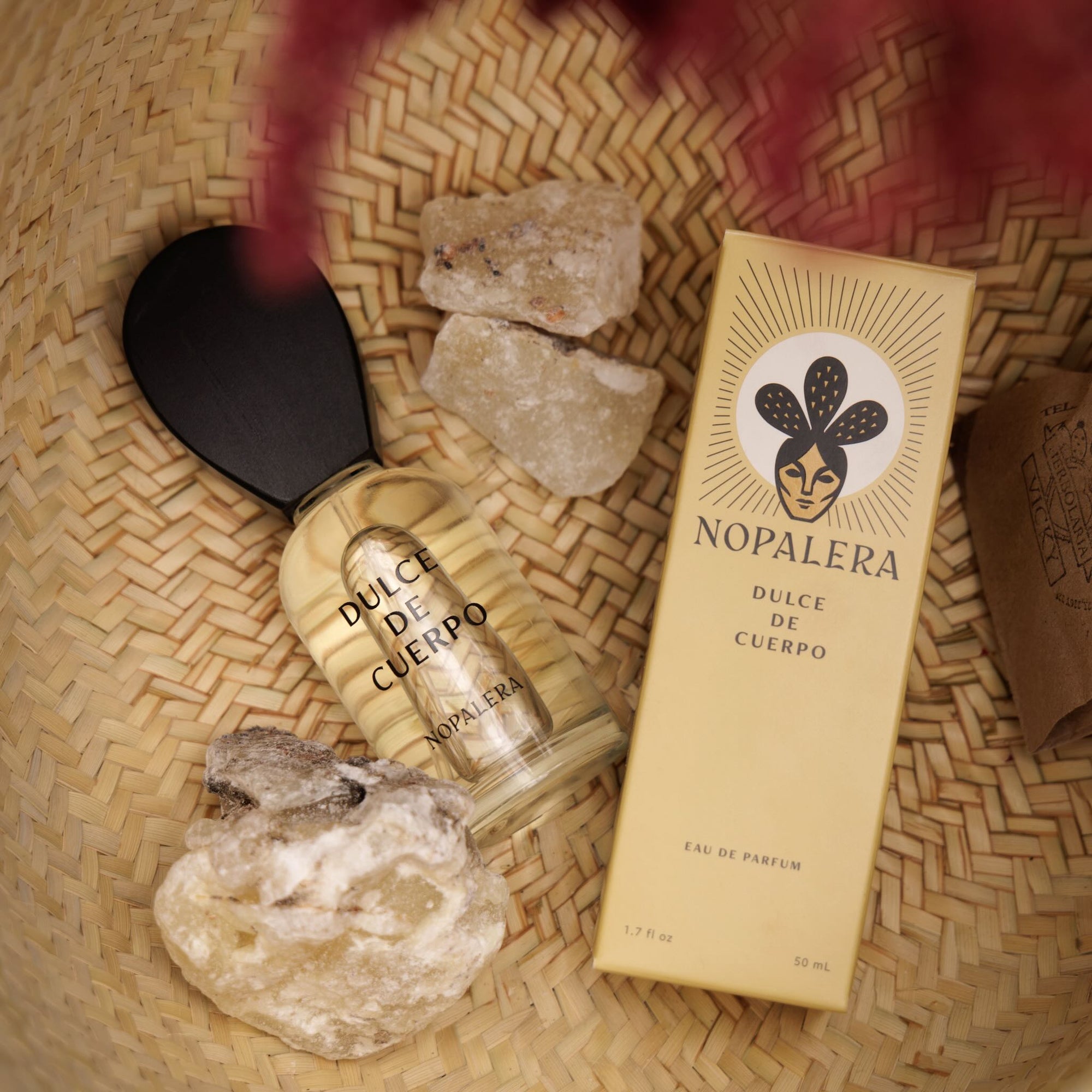 Nopalera Dulce de Cuerpo luxury Mexican  perfume bottle and box displayed with natural elements on a woven background.
