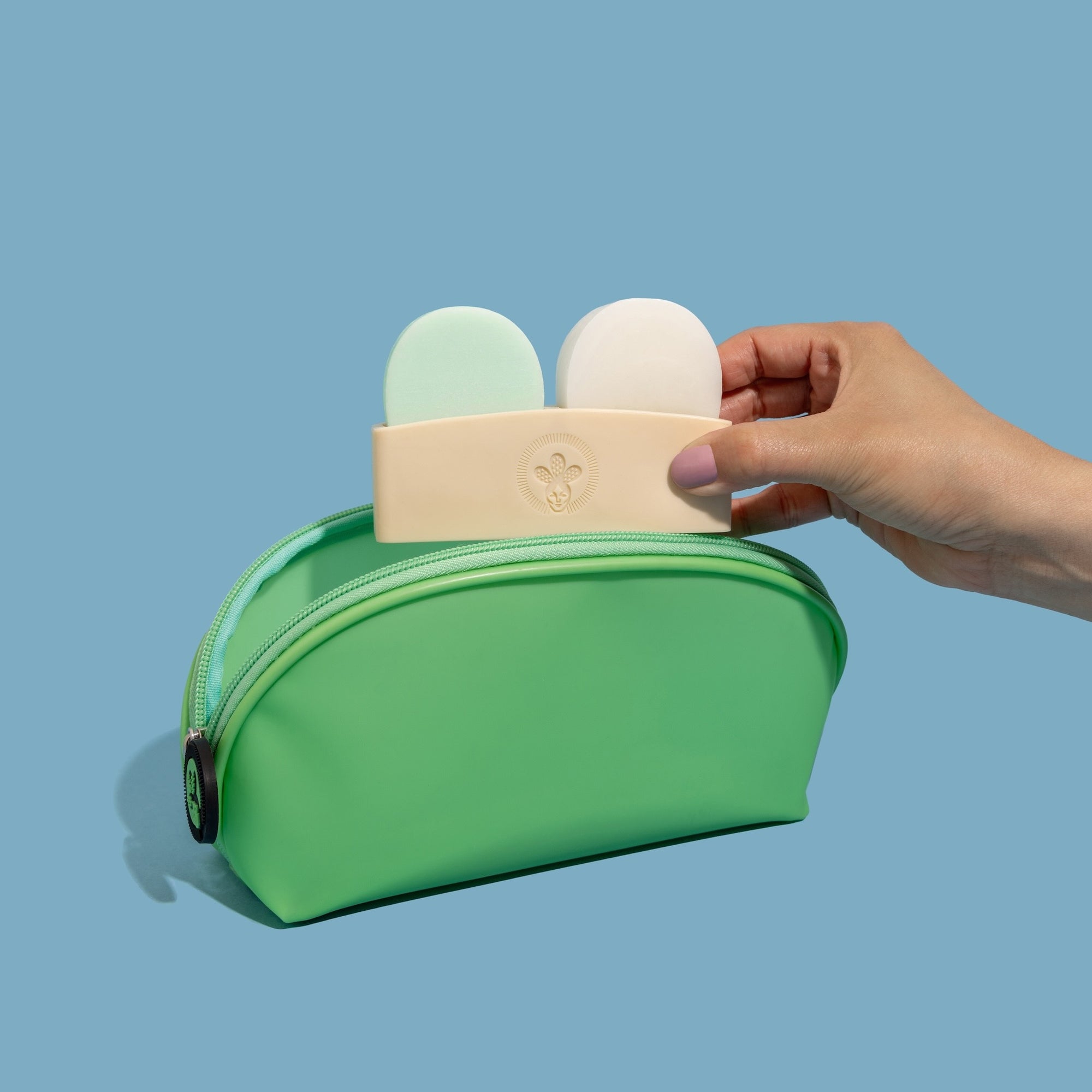 Nopalera shampoo and conditioner bars with green storage pouch on a light blue background