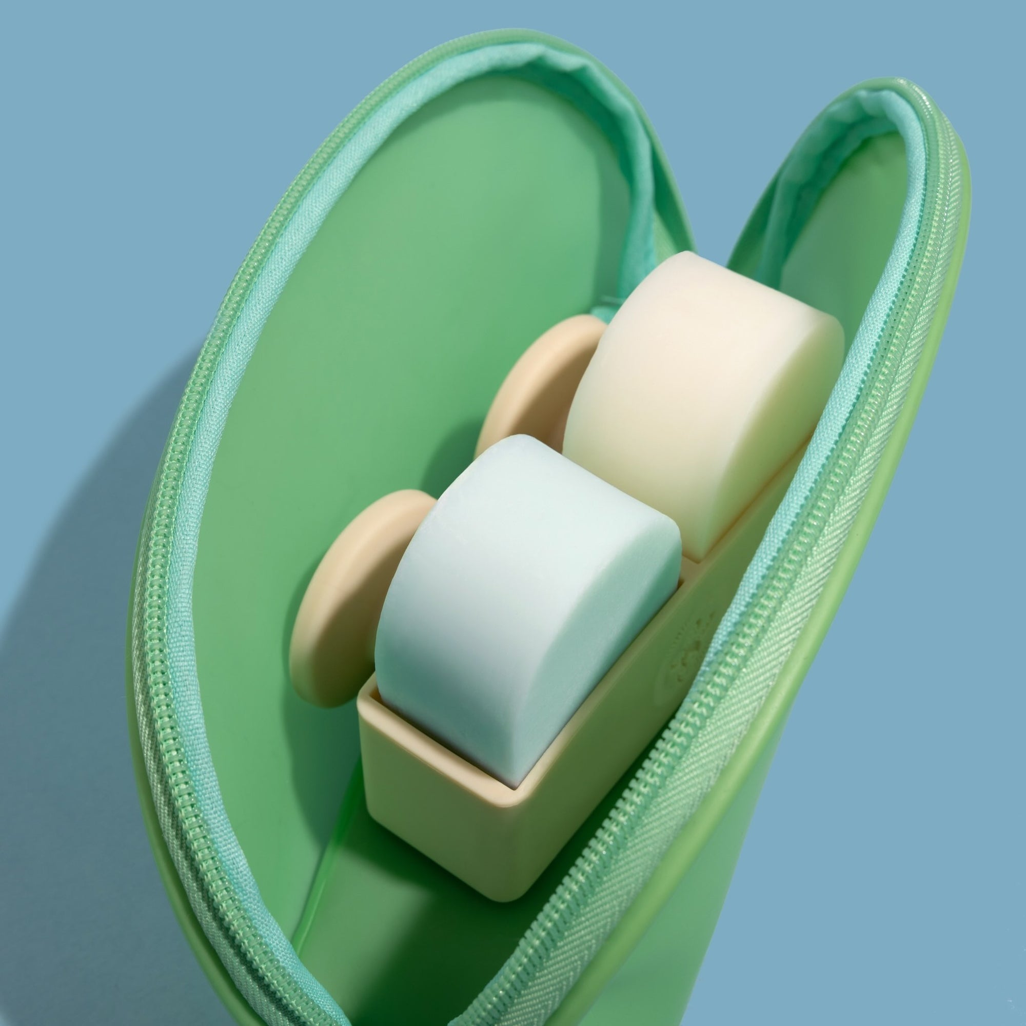 Nopalera shampoo and conditioner bars inside a green travel pouch with soap holder.