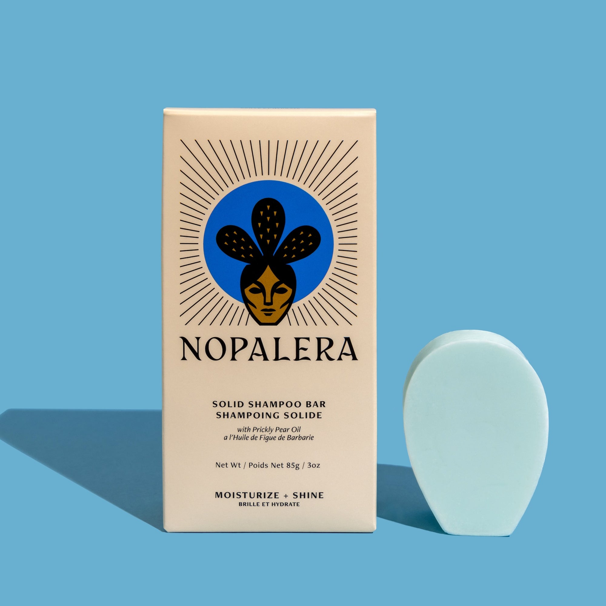 Nopalera Moisturize and Shine shampoo bar with packaging on blue background