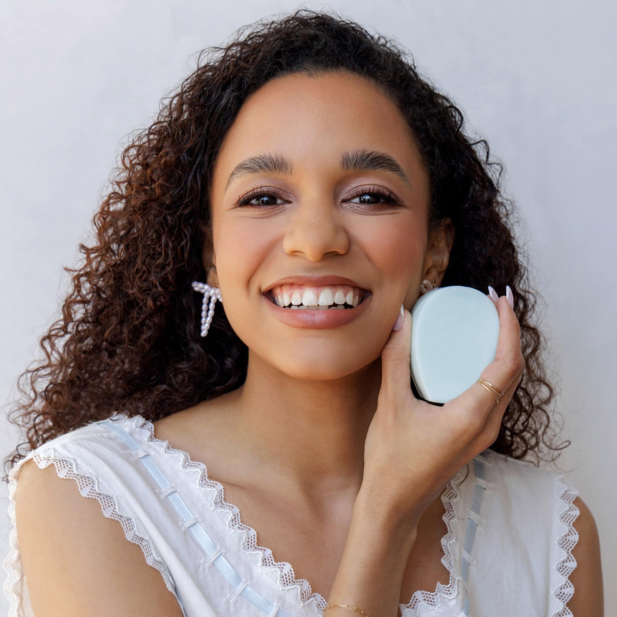 Woman holding a Nopalera shampoo bar with a white background