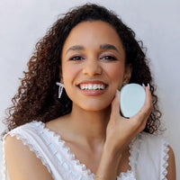 Woman holding a Nopalera shampoo bar with a white background