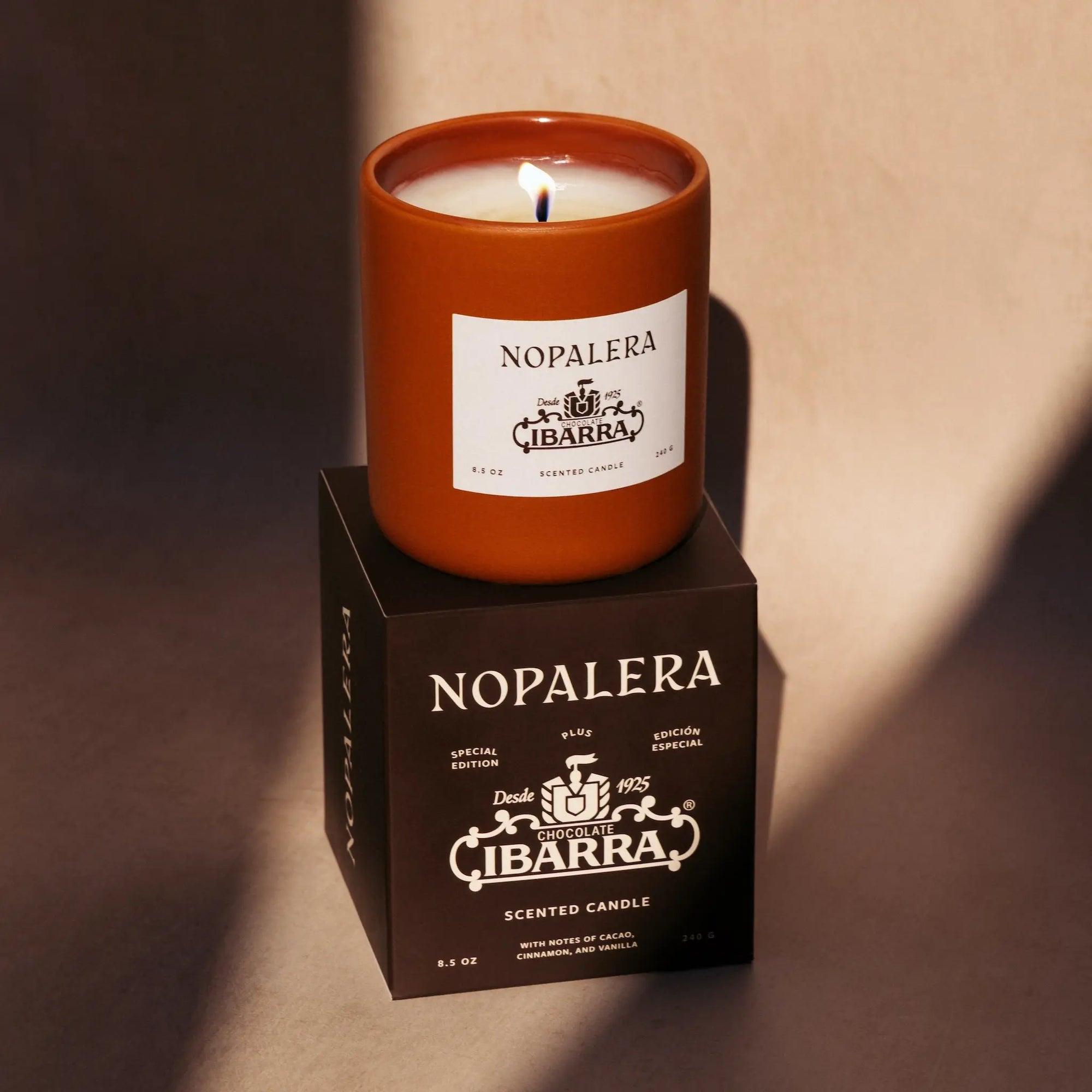 Nopalera Ibarra scented candle on a matching box with a warm glow.