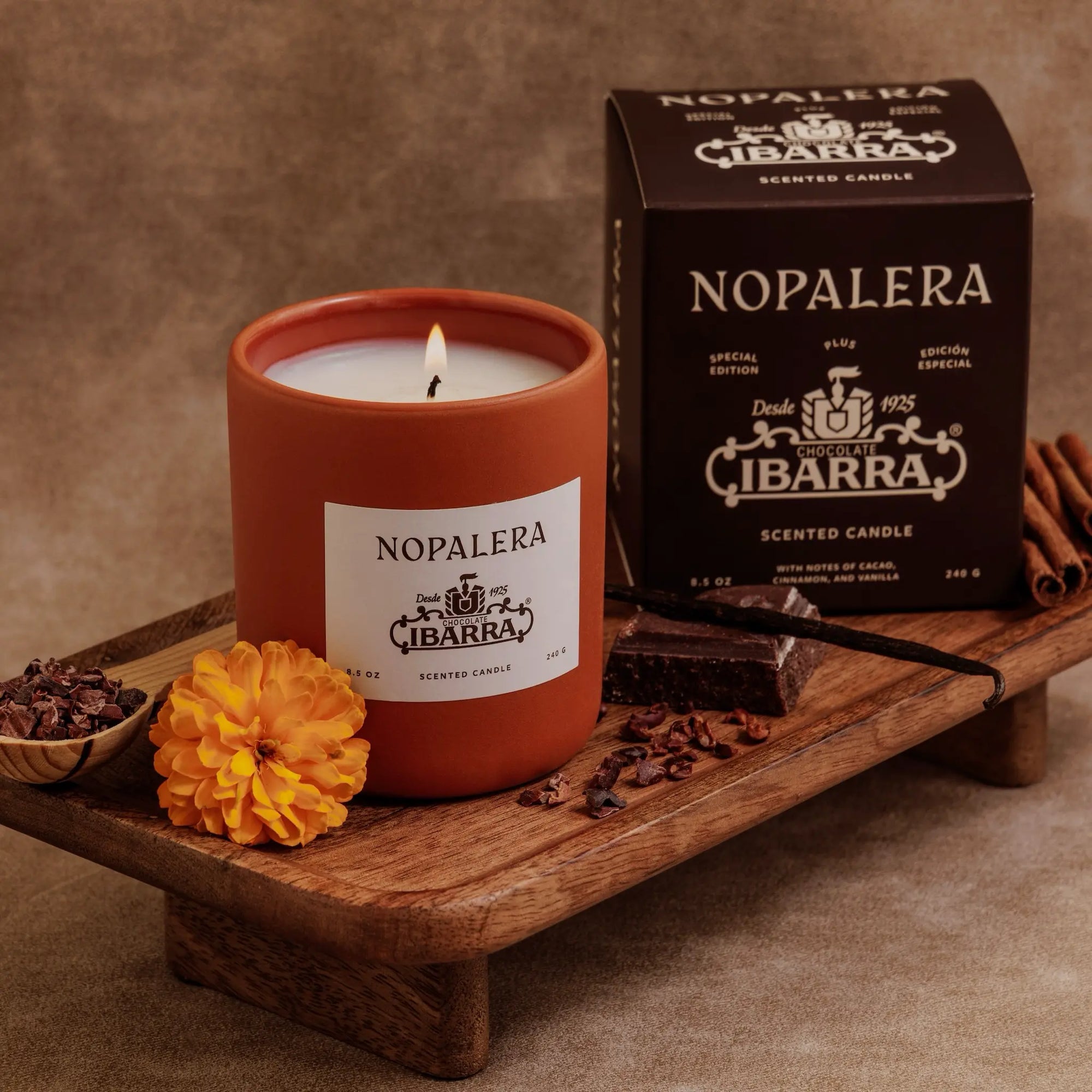 Nopalera scented candle with packaging on a wooden tray against a brown background