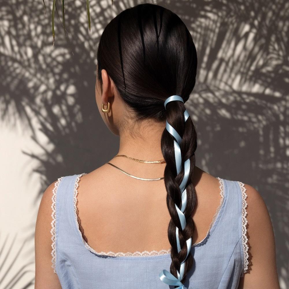 Nopalera woman with long braided hair styled with ribbon, representing results from Nopalera shampoo and conditioner bars