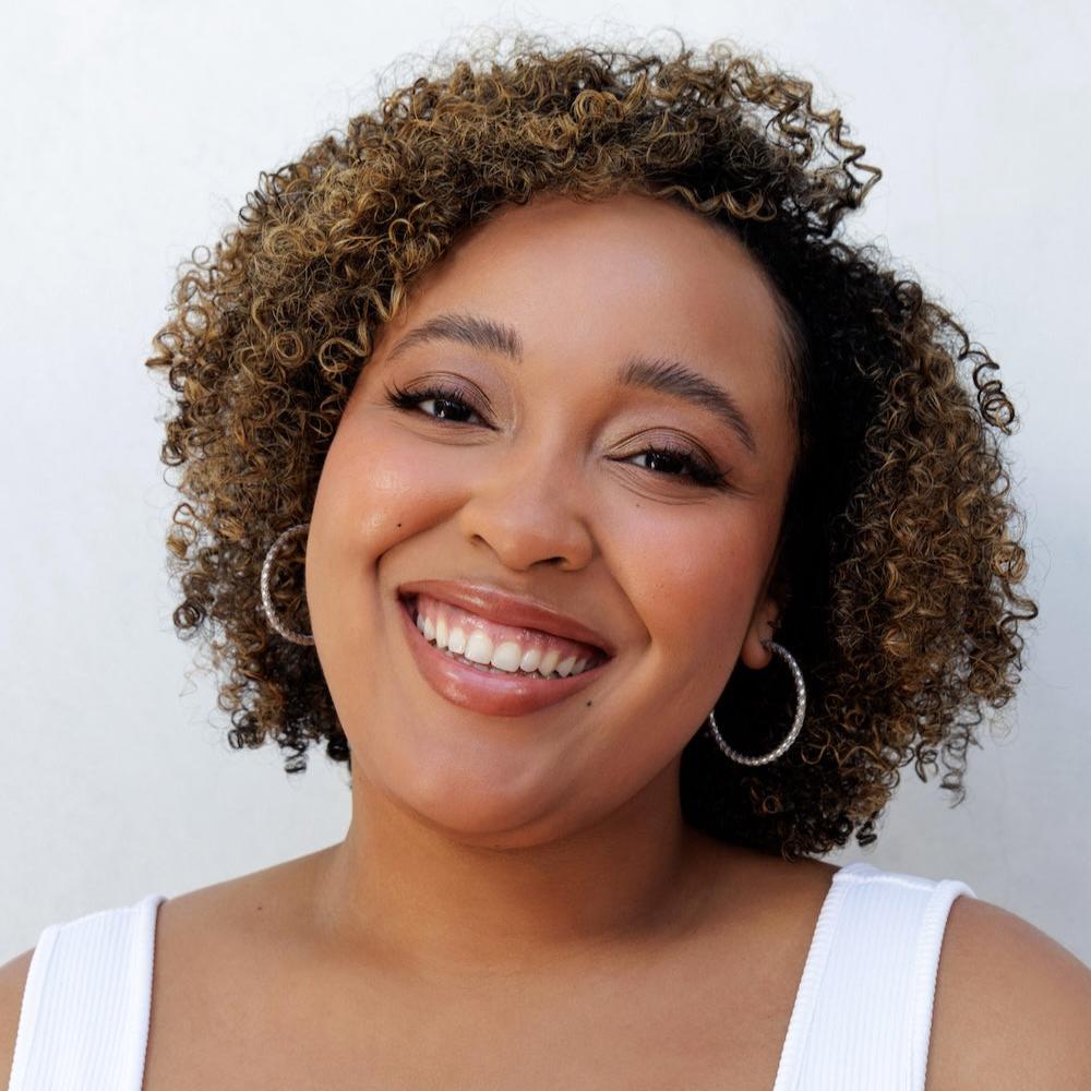 Woman with natural curly hair smiling, showing results from Nopalera shampoo and conditioner bars