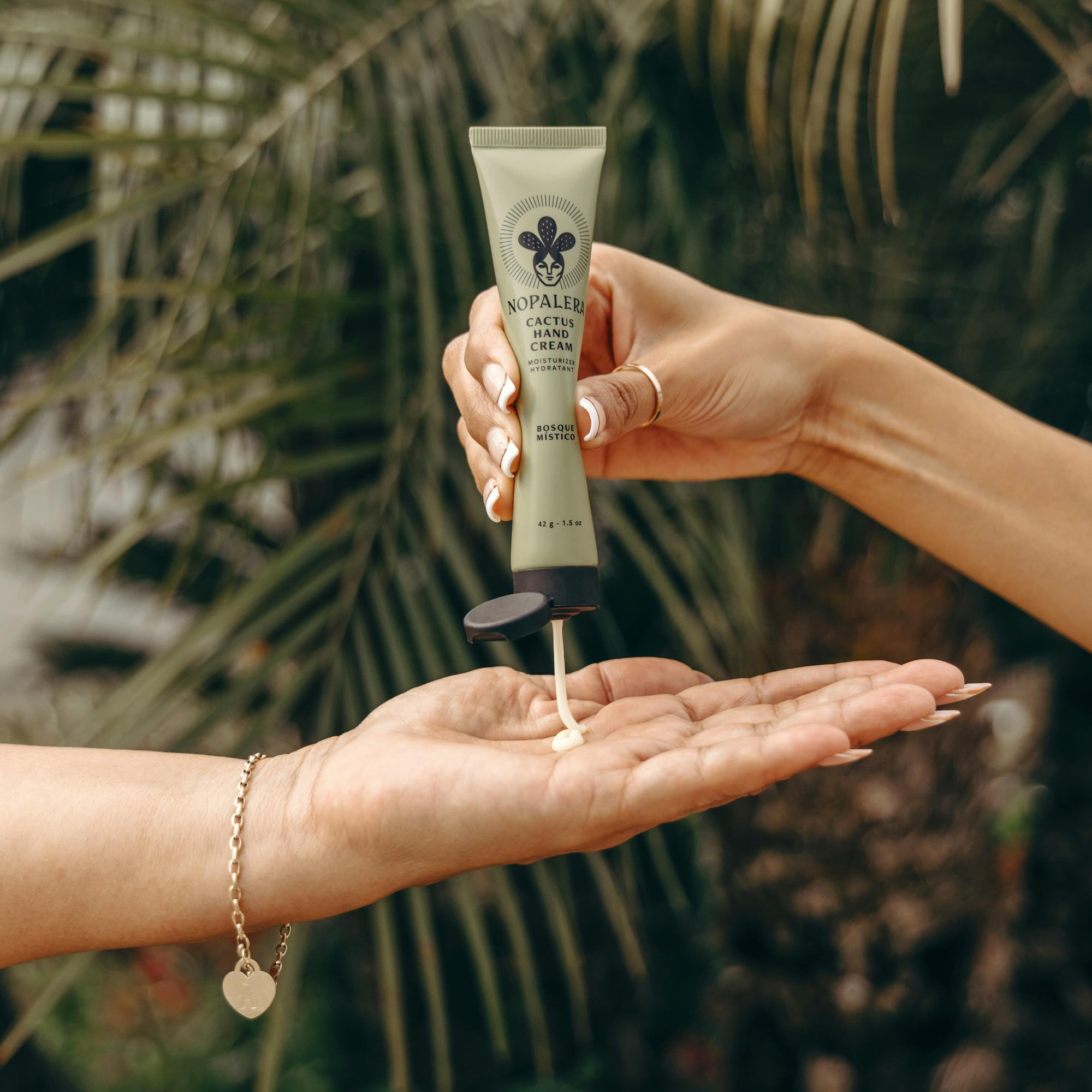 Person applying Nopalera cactus hand cream Bosque Místico with a natural background