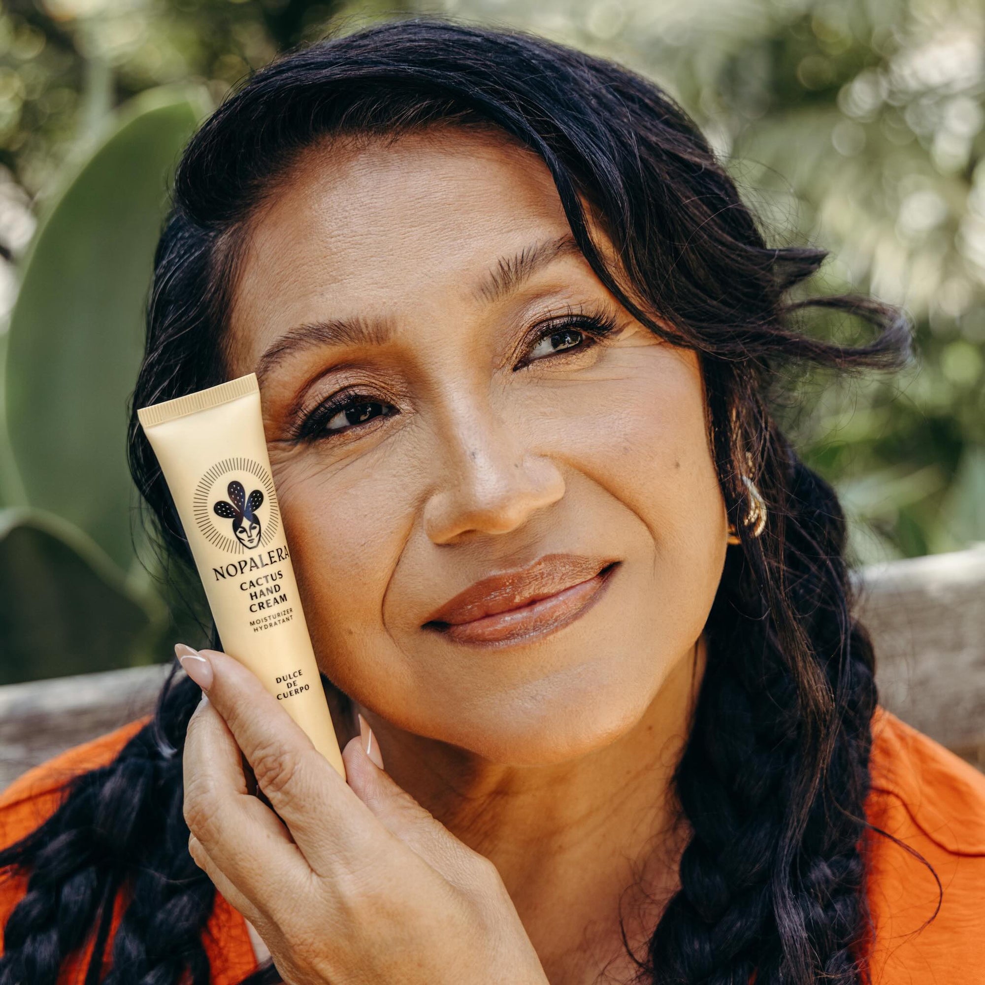 Woman holding Nopalera cactus hand cream Dulce de Cuerpo for hydrated skin.