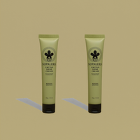 Two tubes of Nopalera Bosque Místico Hand Cream on a green background