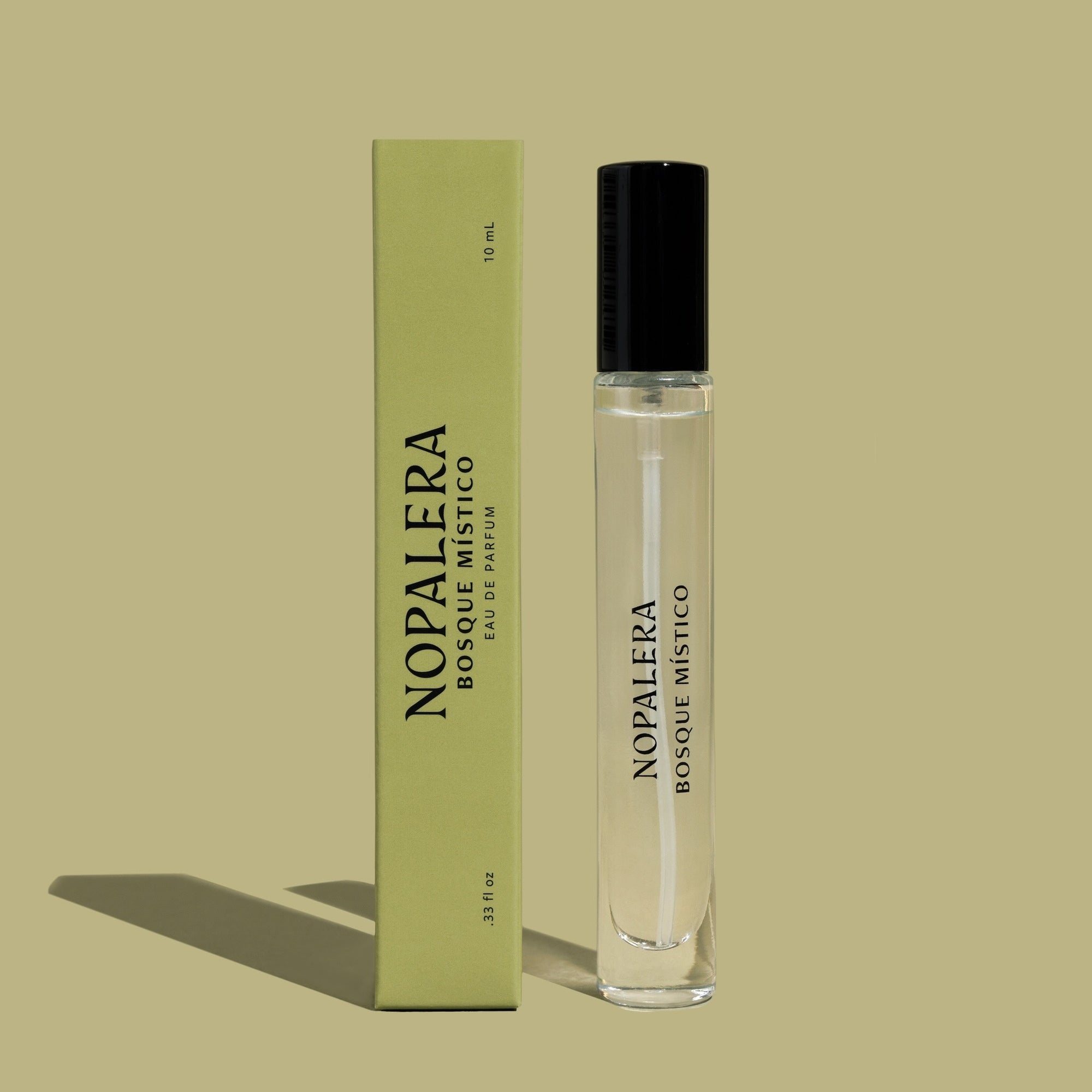 A 10mL Luxury Mexican travel spray bottle  perfume - Bosque Místico with a clear liquid visible inside, labeled 'Nopalera Bosque Místico'. The product is accompanied by a green box with the same labeling.