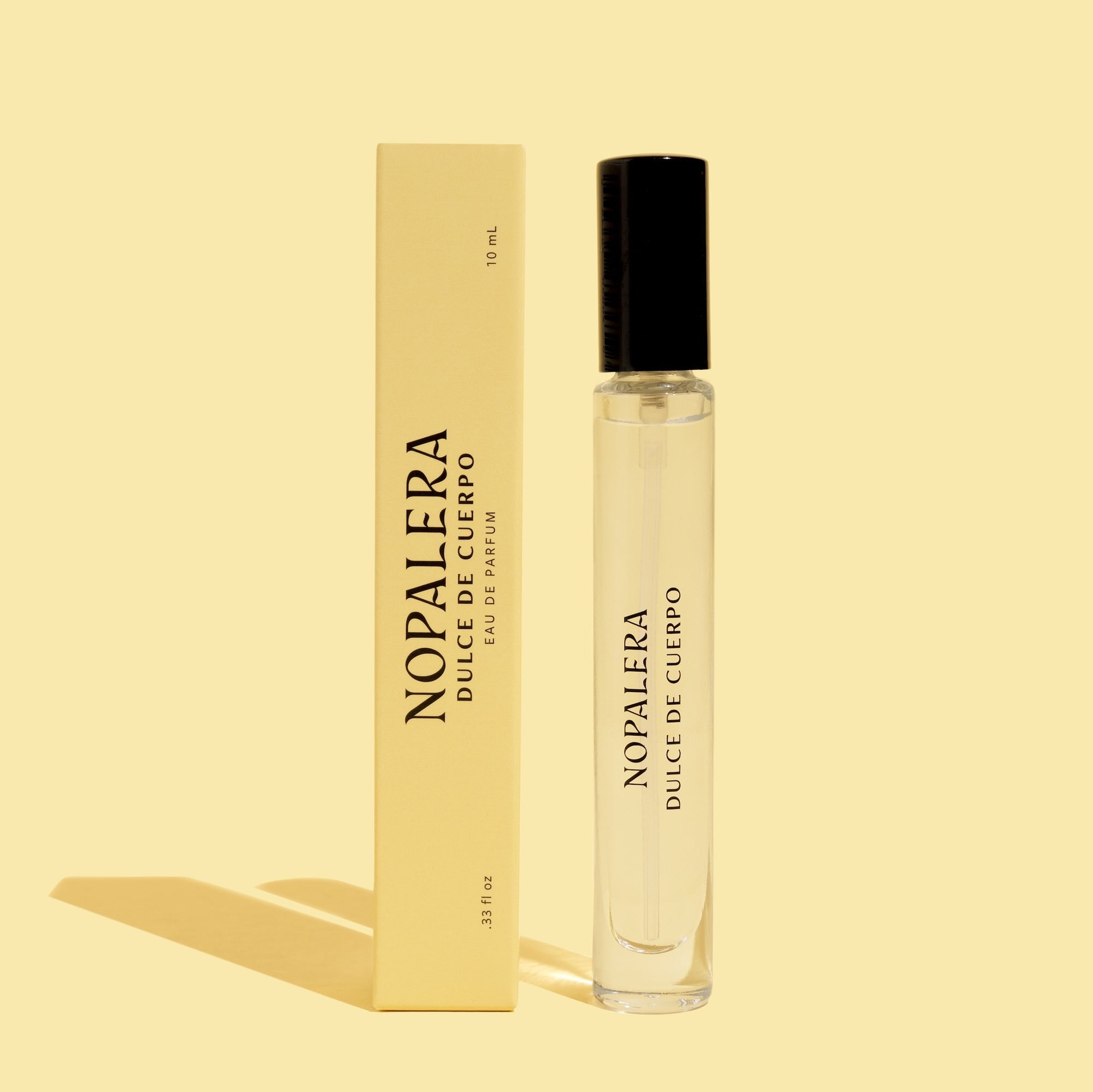 A 10ml Luxury Mexican perfume travel spray bottle labeled ' Nopalera Dulce de Cuerpo' accompanied by its packaging box, both featuring a minimalist design 