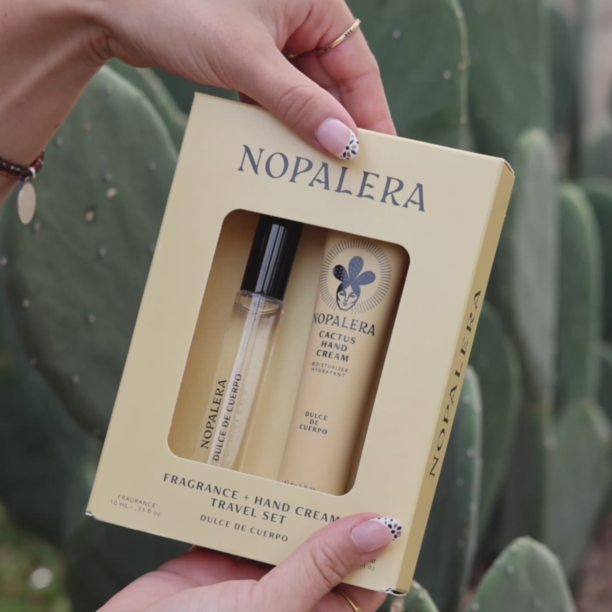 Person applying Nopalera cactus hand cream moisturizer in Dulce de Cuerpo scent with cactus plants in the background