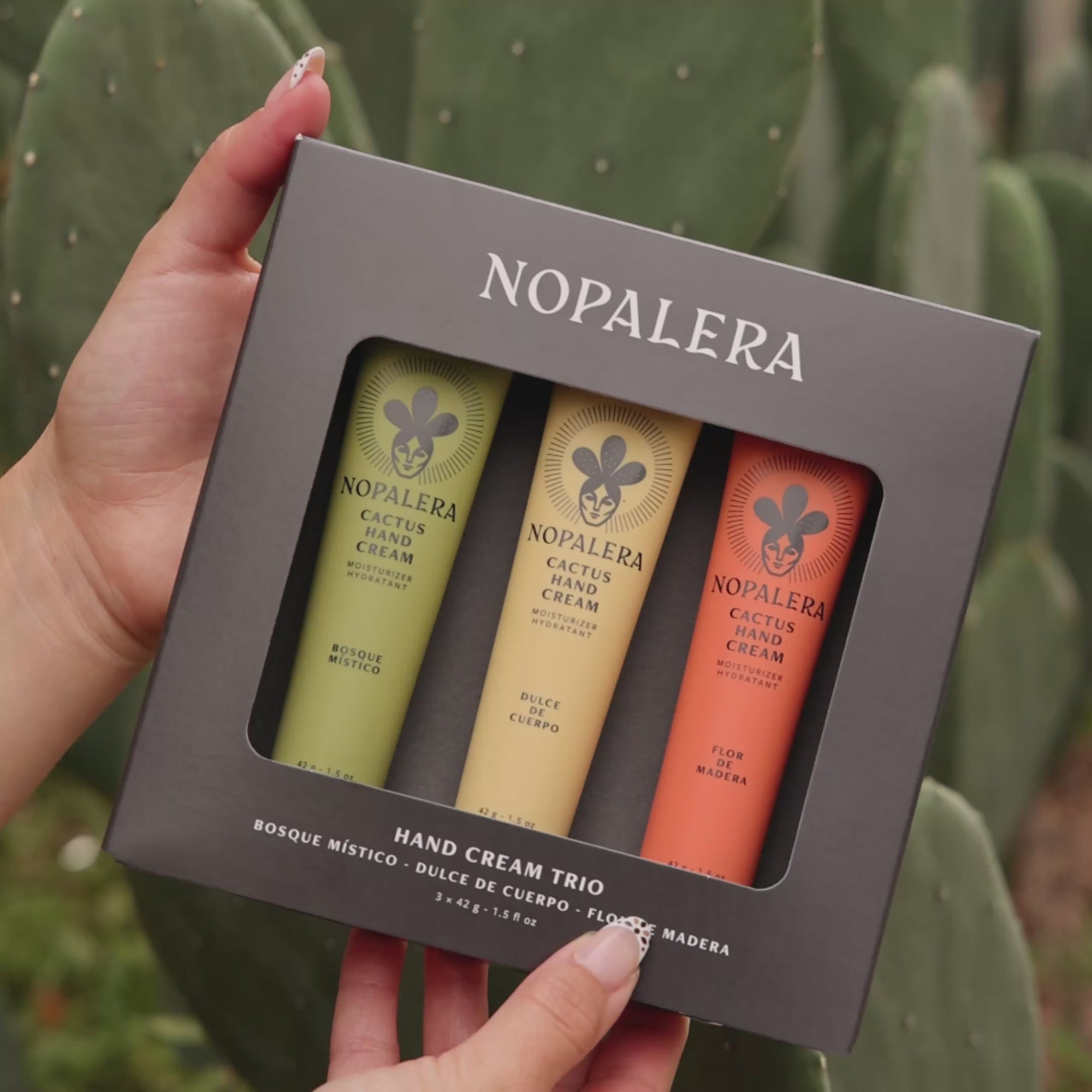 Hands dispensing Nopalera cactus hand cream in different scents with cactus plants in the background