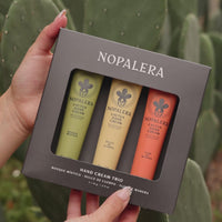Hands dispensing Nopalera cactus hand cream in different scents with cactus plants in the background